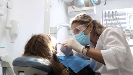 Young woman dentist Reception at the orthodontist Replacement of braces Polishing Gel bondingの写真素材
