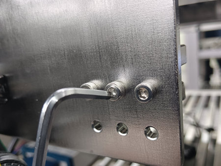 Hex wrench is unscrewing a nut made of stainless steel.