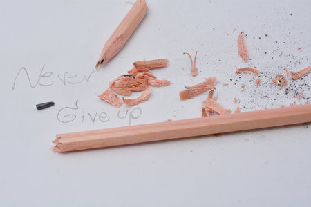 Broken pencil. Writing with a pencil the word nerver give up. White background.