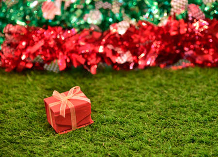 Decoration red gift box on green glass and bokeh lgihtの写真素材