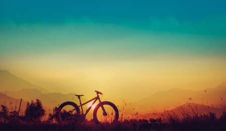 Golden sky sunset and mountain bike silhouette, silhouette fat bike, Silhouette Bicycle  on mountain backgroundの写真素材