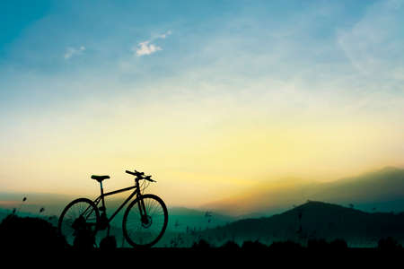 Sunset silhouette and bicycle on beautiful skyの写真素材