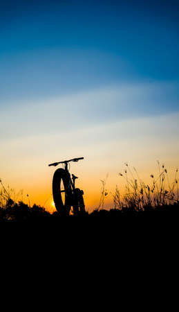 beautiful sunset sky and mountain bike silhouette , silhouette fat bikeの写真素材