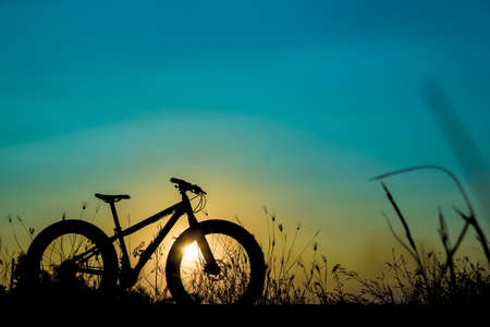 beautiful sunset sky and mountain bike silhouette , silhouette fat bikeの写真素材