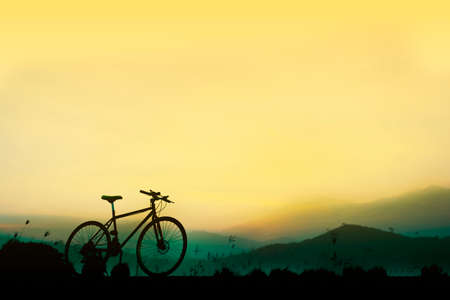 Sunset silhouette and bicycle on beautiful skyの写真素材
