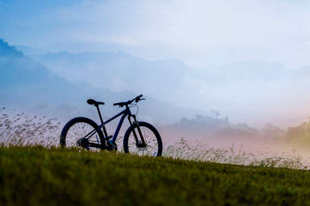 Silhouette Mountain bike on beautiful landscape, Silhouette Bicycle sunset on beautiful landscape mountain and foggyの写真素材