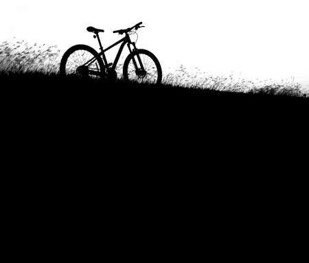 silhouette MTB, bicycle in grass at sunsetの写真素材