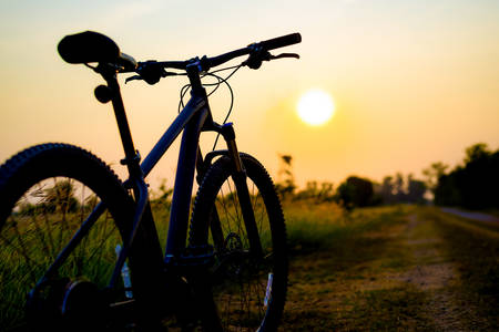 silhouette MTB, bicycle in grass at sunsetの写真素材