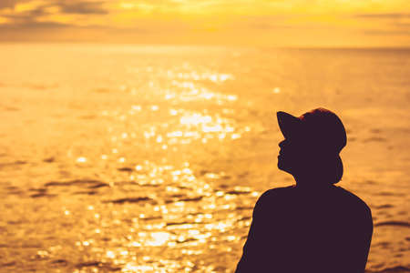 silhouette  people alone sunset on the sea, Sun sky relaxing with waterの写真素材