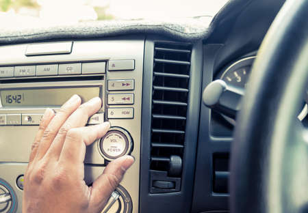 Hand adjust volume audio button in the carの写真素材