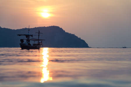 Traditional thai boat at sunset on sea in Thailandの写真素材