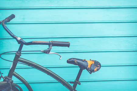 Old black leather of bike seat on blue woodの写真素材