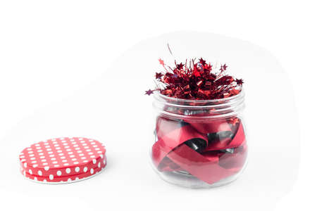 Glass bottle and red ribbon on white backgroundの写真素材