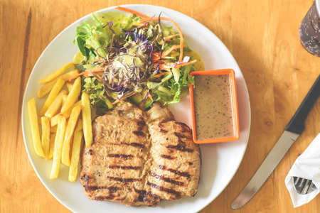 The steak with the black pepper and vegetable and french fries top viewの写真素材