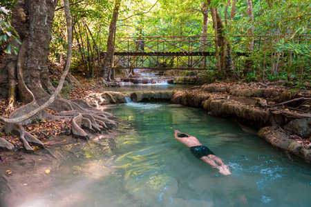 Man Swimming in clear water fallの写真素材