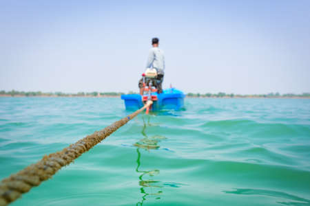 Young man Dragging Bamboo raft in the water at Roi Et Thailand.