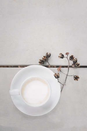 Cup of hot latte art coffee on wooden floor White color background and dry flower, in top view.の写真素材