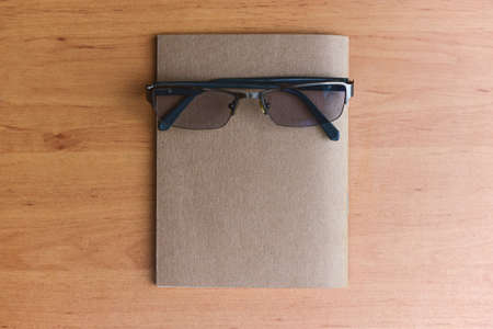 Close Up glasses and book placed on table in the living room, Eye care to read a book. Education and knowledge concepts.の写真素材