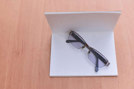 Close Up glasses and book placed on table in the living room, Eye care to read a book. Education and...