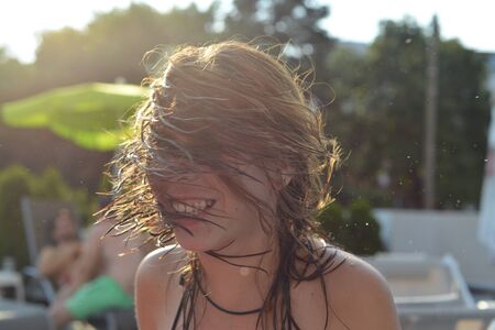 summer wet hair girl having fun at the poolの写真素材