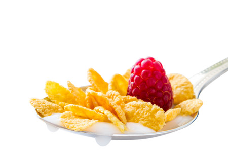 Cereal in spoon with raspberry, isolated on whiteの写真素材