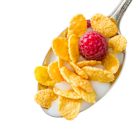 Cereal in spoon with raspberry, isolated on whiteの写真素材