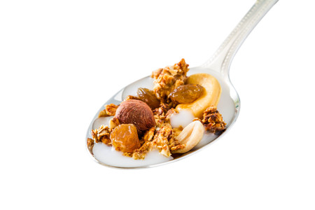 Granola in spoon with nuts, isolated on whiteの写真素材