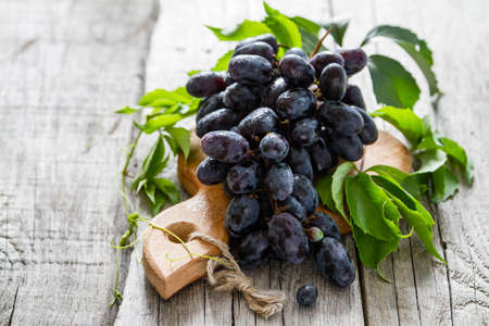 Grapes with leaf on rustic wood backgroundの写真素材