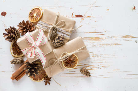 Christmas presents in rustic wrap, white wood background, top viewの写真素材