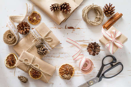 Christmas presents in rustic wrap, white wood background, top viewの写真素材