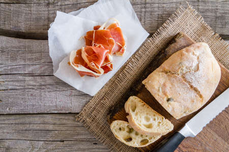 appetizer - ciabatta ham basil tomato, rustic wood background, top viewの写真素材