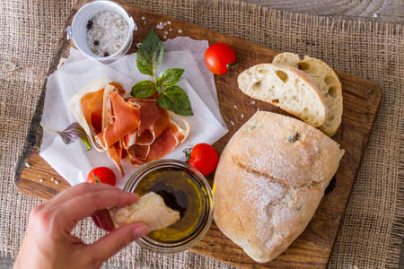 appetizer - ciabatta ham basil tomato, rustic wood background, top viewの写真素材