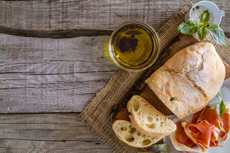 appetizer - ciabatta ham basil tomato, rustic wood background, top viewの写真素材
