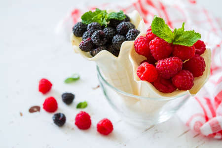 Selection of berries in waffle cones white wood backgroundの写真素材
