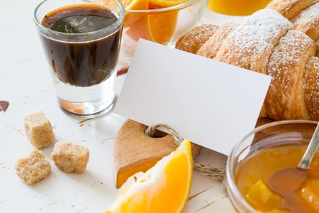 Breakfast note - croissants coffee jam oranges white wood backgroundの写真素材
