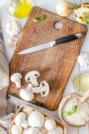 Risotto ingredients on wood board, white wood background, top viewの写真素材