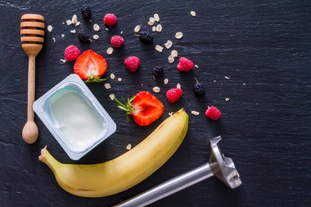 Banana strawberry smoothie ingredients dark stone backgroundの写真素材