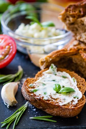 Garlic bread with herbs dark stone background