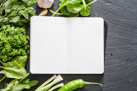 Selection of herbs and spices, notepad, dark stone background, copy space, top viewの写真素材