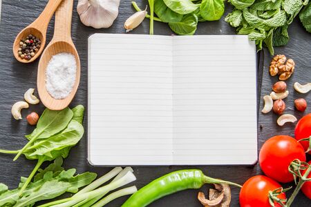 Selection of herbs and spices, notepad, dark stone background, copy space, top viewの写真素材
