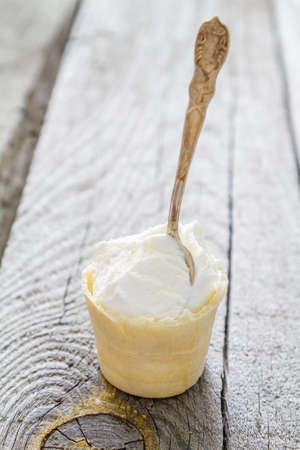 Ice cream in waffle cone on rustic wood backgroundの写真素材