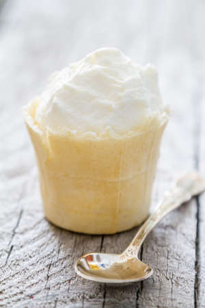 Ice cream in waffle cone on rustic wood backgroundの写真素材