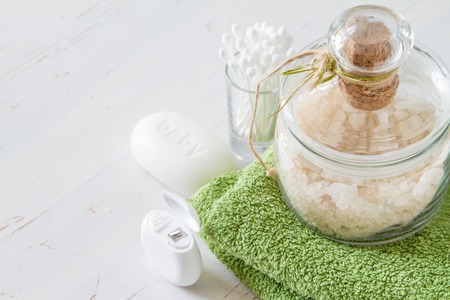 Green bath salt and towel, white wood backgroundの写真素材