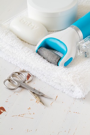 Pedicure accessories on white wood background, closeup