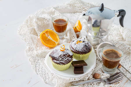 Chocolate and orange cupcake with coffee, white wood backgroundの写真素材