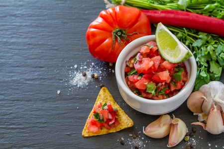 Salsa sauce and ingredients, dark stone backgroundの写真素材