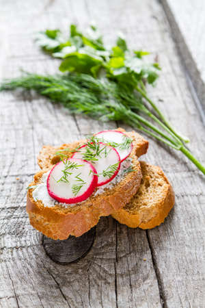 Radish and cucumber sandwich and ingredients, rustic wood background, closeupの写真素材