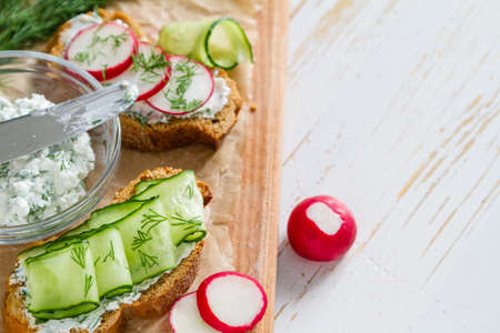Radish and cucumber sandwich and ingredients, white wood backgroundの写真素材
