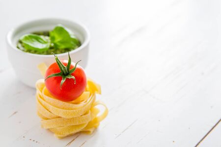 Pesto sauce with pasta, white wood background, copy spaceの写真素材
