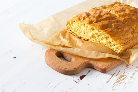 Corn bread cut in peaces on white wood background, copy spaceの写真素材